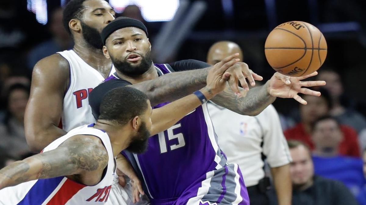 Sacramento Kings forward DeMarcus Cousins (15) passes the ball as Detroit Pistons center Andre Drummond, rear, and forward Marcus Morris close in during the second half of an NBA basketball game, Monday, Jan. 23, 2017, in Auburn Hills, Mich.