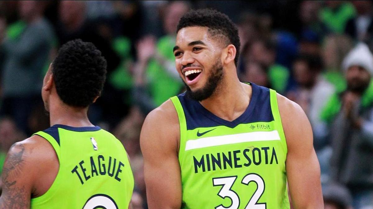 Minnesota Timberwolves center Karl Anthony-Towns (32) and guard Jeff Teague (0) celebrate in the first quarter of an NBA basketball game against the Phoenix Suns, Saturday, Dec. 16, 2017, in Minneapolis.