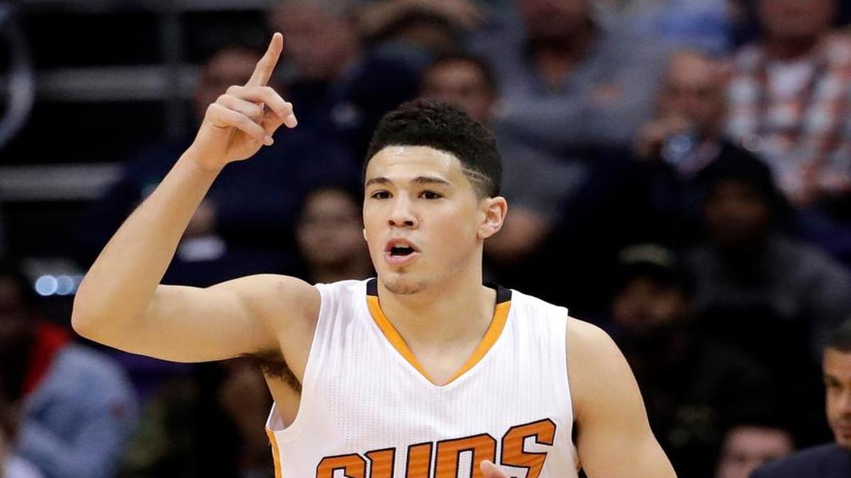 Phoenix Suns guard Devin Booker (1) points after making a basket against the Memphis Grizzlies during the first half of an NBA basketball game, Monday, Jan. 30, 2017, in Phoenix.