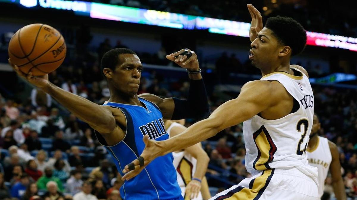 Dallas Mavericks guard Rajon Rondo, left, passes around New Orleans Pelicans forward Anthony Davis during the first half of an NBA basketball game, Sunday, Jan. 25, 2015, in New Orleans.