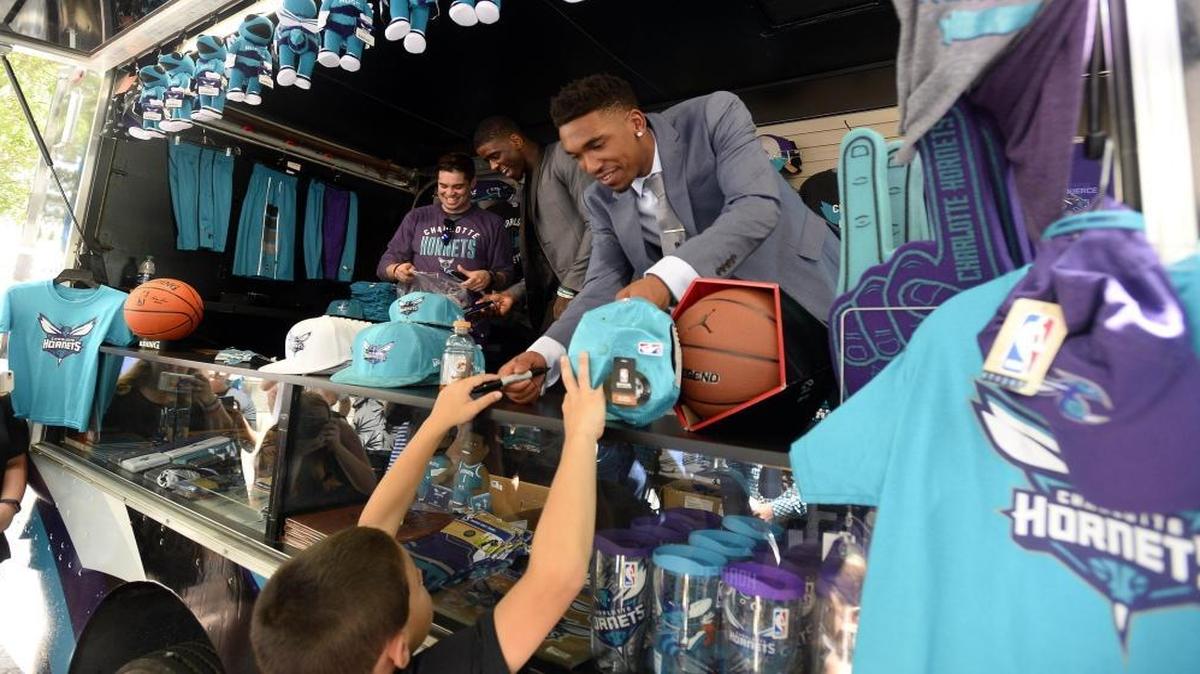 Charlotte Hornets 2017 draft picks Malik Monk, center, hands an autographed hat back to a fan as Dwayne Bacon, rear, laughs with a team staff member while greeting fans in uptown Charlotte on Friday.