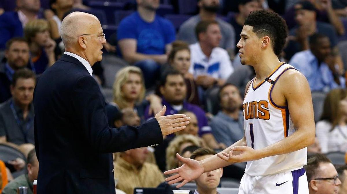 Phoenix Suns guard Devin Booker (1) slaps hands with interim head coach Jay Triano, left, as Booker comes out of the game during the second half of an NBA basketball game against the Brooklyn Nets Monday, Nov. 6, 2017, in Phoenix. The Nets defeated the Suns 98-92. Booker reached the 3,000 point milestone in the game.