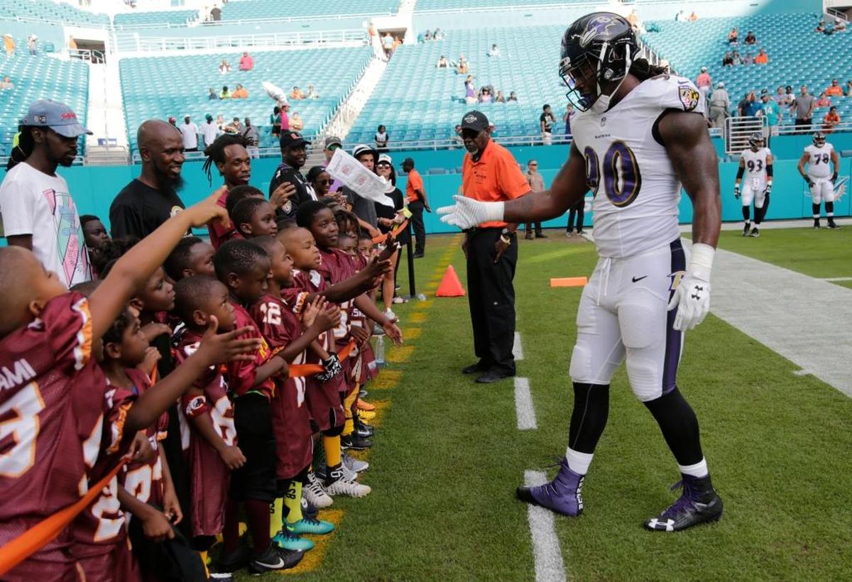 Baltimore Ravens outside linebacker Za’Darius Smith (90) greets young fans, before an NFL preseason football game against the Miami Dolphins, Thursday, Aug. 17, 2017, in Miami Gardens, Fla.