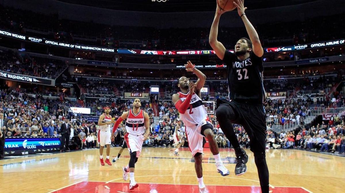 Minnesota Timberwolves center Karl-Anthony Towns (32) shoots in front of Washington Wizards guard John Wall (2) late in the second overtime period of an NBA basketball game Friday, March 25, 2016, in Washington. The Timberwolves won 132-129.