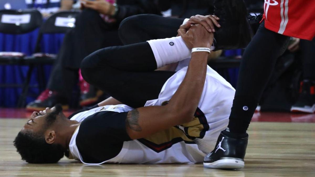 Anthony Davis of the New Orleans Pelicans reacts in pain as he injures his right ankle during a preseasons match against Houston Rockets in Beijing, China, Wednesday, Oct. 12, 2016. Davis fell to the court early in the first quarter of Wednesday's game in Beijing, the last of the NBA's two exhibitions in China. He re-entered the game briefly, but soon walked to the locker room.