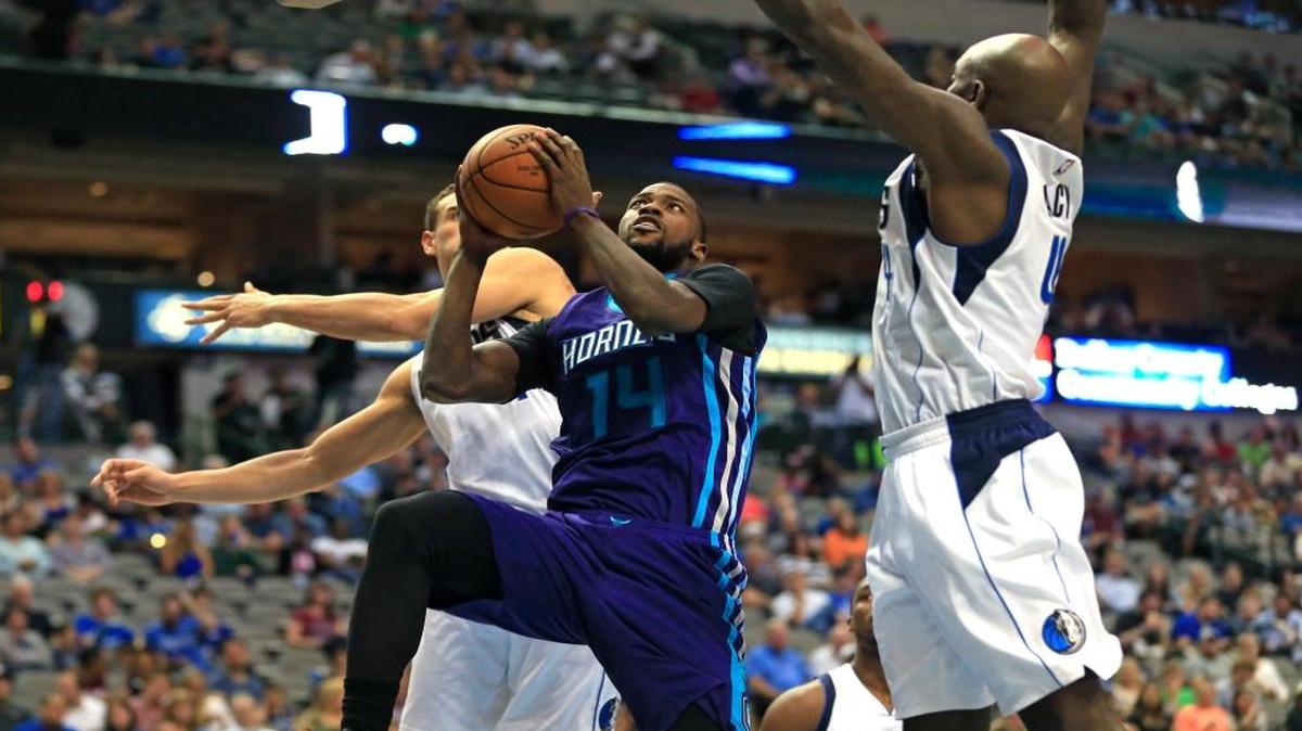 Charlotte Hornets forward Michael Kidd-Gilchrist (14) gets inside to shoot as Dallas Mavericks Dwight Powell, left, and Quincy Acy, right, defend during the first half of an NBA preseason basketball game, Monday, Oct. 3 , 2016, in Dallas.