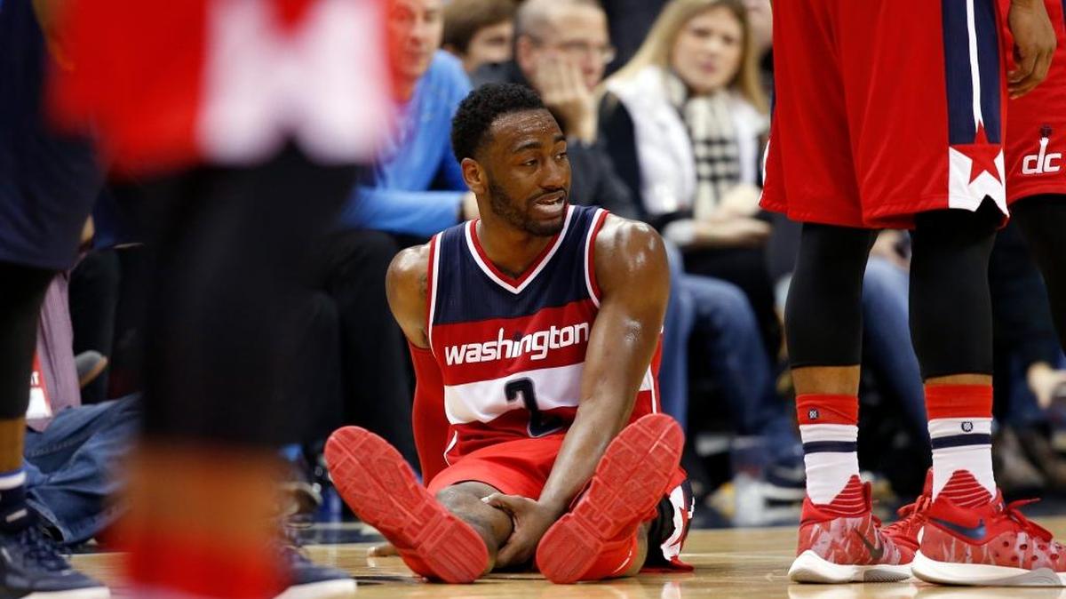 Wizards guard John Wall (2) held his leg as he sat on the court in the second half against the Mavericks on Sunday.