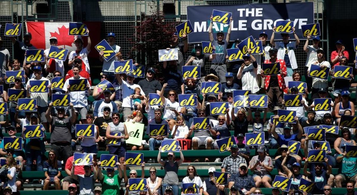 Fans in the "Maple Grove" cheering section hold up "eh" cards in support of Seattle Mariners starting pitcher James Paxton, from Canada, as Paxton throws against the New York Mets in the second inning of a baseball game, Sunday, July 30, 2017, in Seattle.