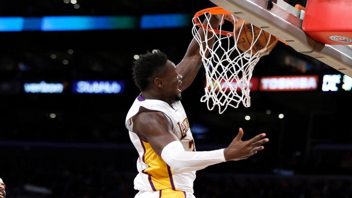 Los Angeles Lakers forward Julius Randle, right, dunks over Phoenix Suns guard Devin Booker (1) during the first half of an NBA basketball game in Los Angeles, Sunday, Nov. 6, 2016.