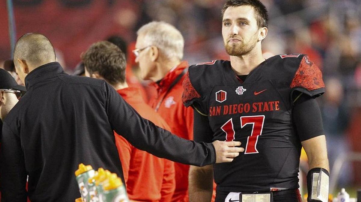 Aztecs quarterback Maxwell Smith stood at the bench after getting injured during the first quarter.