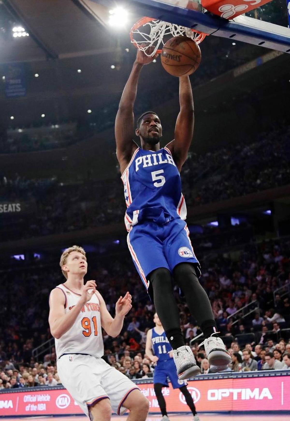 The Philadelphia 76ers' Alex Poythress (5) dunks the ball in front of New York Knicks' Mindaugas Kuzminskas (91) during the first half of an NBA basketball game, Wednesday, April 12, 2017, in New York.