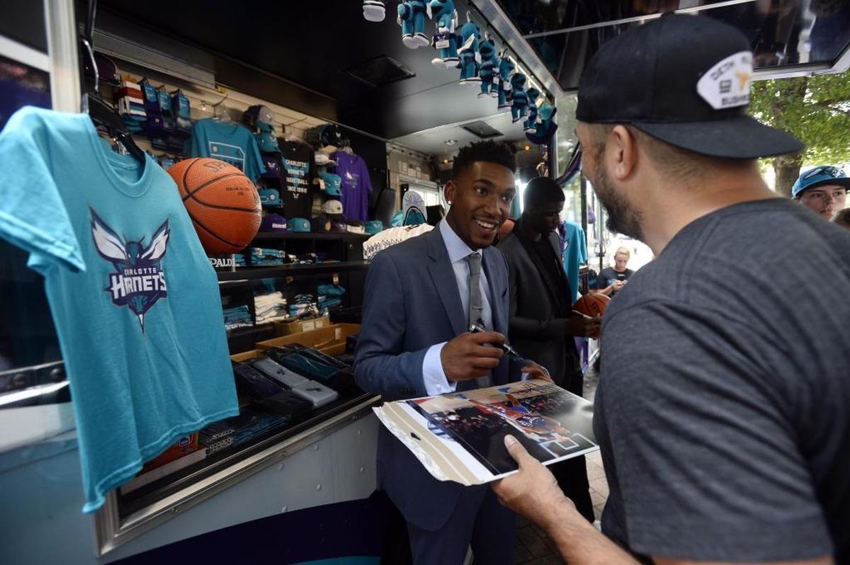 Charlotte Hornets draft pick Malik Monk signs an autograph while he and fellow draft pick Dwayne Bacon greet fans in uptown Charlotte on Friday, June 23, 2017.