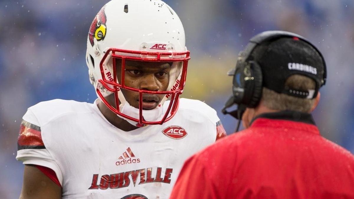 Louisville quarterback Lamar Jackson, left, gets sideline instruction from Louisville head coach Bobby Petrino in the second half. The University of Kentucky hosted the University of Louisville, Saturday, Nov. 28, 2015, at Commonwealth Stadium in Lexington.