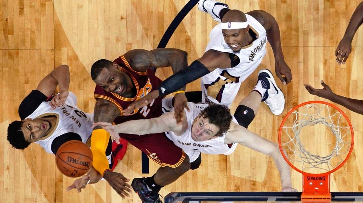 Cleveland Cavaliers forward LeBron James (23) reaches for the ball between New Orleans Pelicans forward Anthony Davis, left, center Omer Asik and forward Dante Cunningham, top right, during the second half in New Orleans on Friday, Dec. 4, 2015. The Pelicans won 114-108 in overtime.