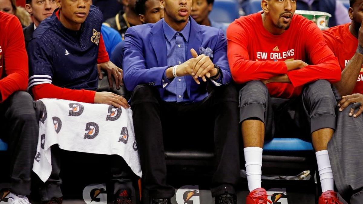 New Orleans Pelicans forward Anthony Davis, center, sits on the bench because of injuries with teammates center Alexis Ajinca, right, and guard Tim Frazier, left, in the first half of an NBA basketball game in New Orleans, Sunday, March 20, 2016.