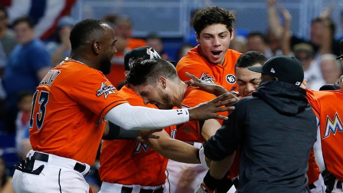 Miami Marlins players mobbed JT Riddle after he hit a two-run home run during the ninth inning against the New York Mets on April 16 in Miami. The Marlins defeated the Mets 4-2.