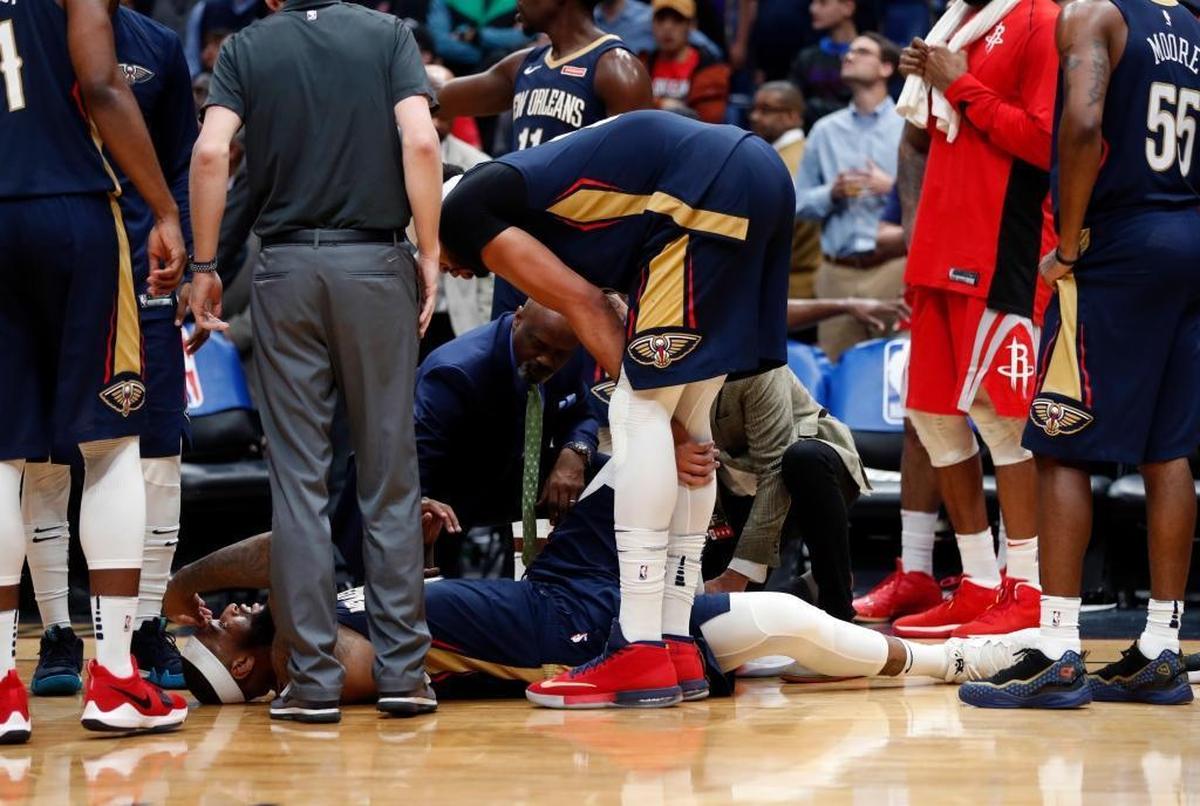 New Orleans Pelicans center DeMarcus Cousins lies on the court while being tended to after injuring his left achilles tendon, according to the team, in the second half of an NBA basketball game against the Houston Rockets in New Orleans, Friday, Jan. 26, 2018. The Pelicans won 115-113.