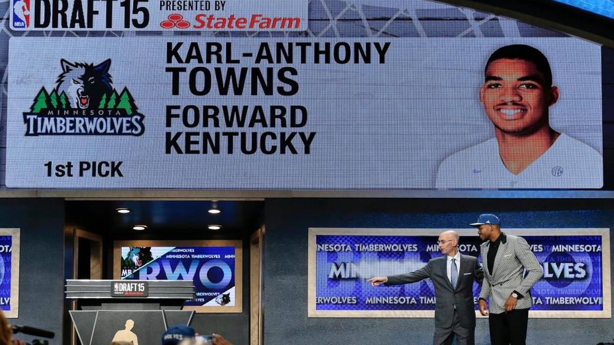 Karl-Anthony Towns, right, is directed off stage by NBA Commissioner Adam Silver after being selected first overall by the Minnesota Timberwolves during the NBA basketball draft, Thursday, June 25, 2015, in New York.