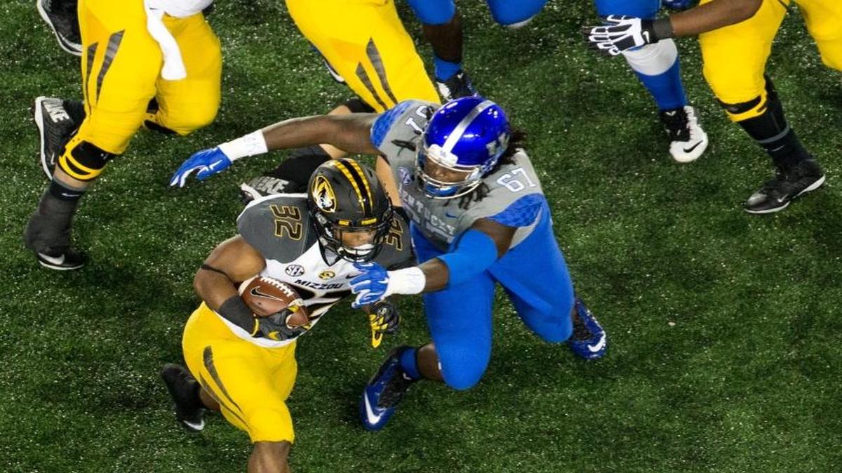 Kentucky defensive tackle Cory Johnson (67) brought down Missouri running back Russell Hansbrough (32) during the first half on Sept. 26, 2015.