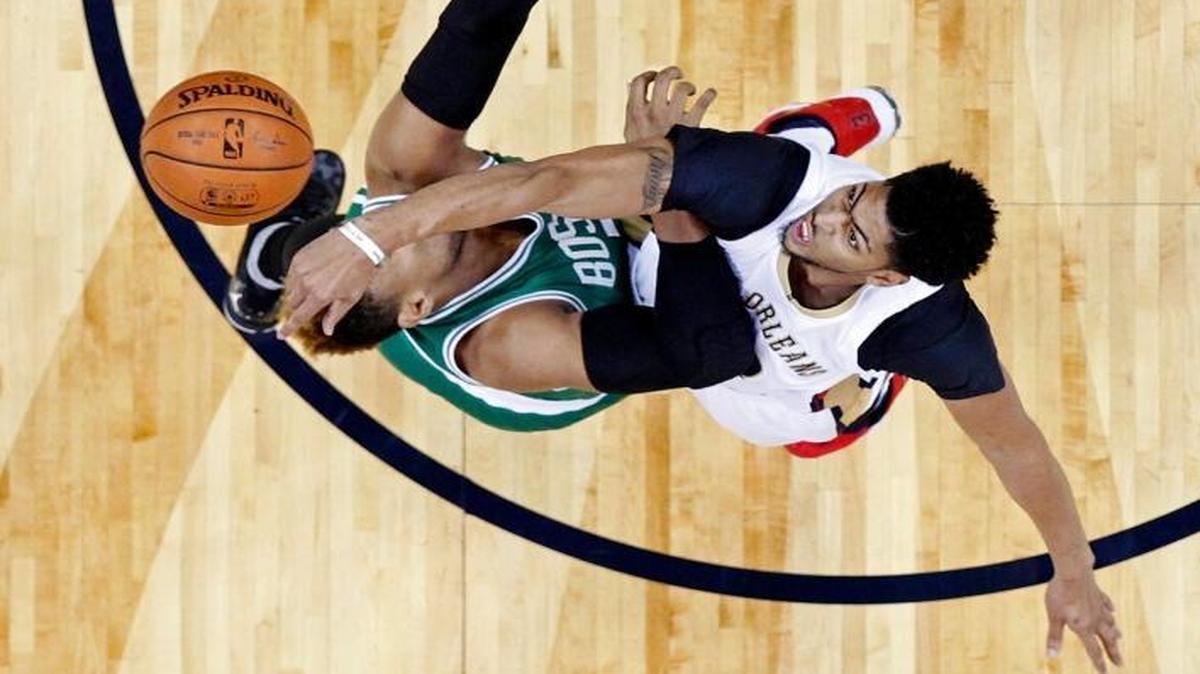 New Orleans Pelicans forward Anthony Davis (23) knocked the ball away from Boston Celtics center Jared Sullinger, with Pelicans guard Tyreke Evans (1) posting under the basket in the first half of an NBA basketball game in New Orleans, Monday, Dec. 7, 2015. The Celtics won 111-93.