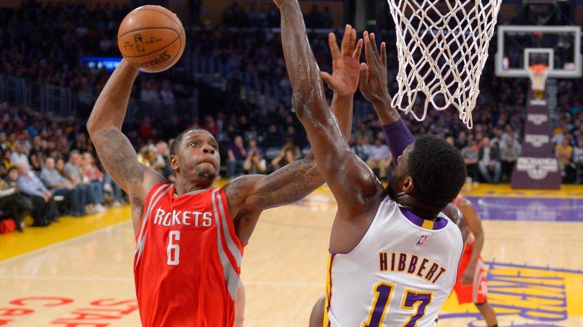 Houston Rockets forward Terrence Jones, left, goes up for a dunk as Los Angeles Lakers center Roy Hibbert defends during the first half of an NBA basketball game, Sunday, Jan. 17, 2016, in Los Angeles.
