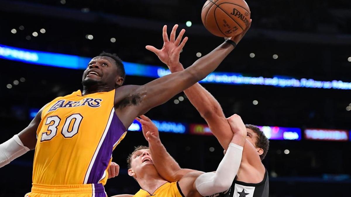 Los Angeles Lakers forward Julius Randle, left, grabs a rebound as center Timofey Mozgov, of Russia, and Brooklyn Nets center Brook Lopez battle in the background during the second half of an NBA basketball game, Tuesday, Nov. 15, 2016, in Los Angeles. The Lakers won 125-118.