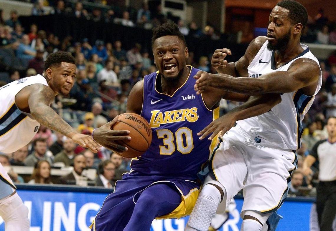 Los Angeles Lakers forward Julius Randle (30) drives between Memphis Grizzlies forwards JaMychal Green, right, and Jarell Martin in the first half of an NBA basketball game Saturday, March 24, 2018, in Memphis, Tenn.