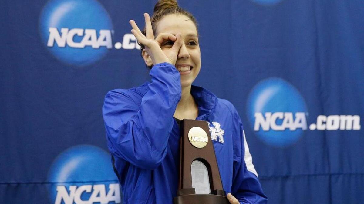 UK’s Danielle Galyer gestured to her teammates after receiving the trophy for winning the 200-yard backstroke at the NCAA women’s swimming and diving championships.