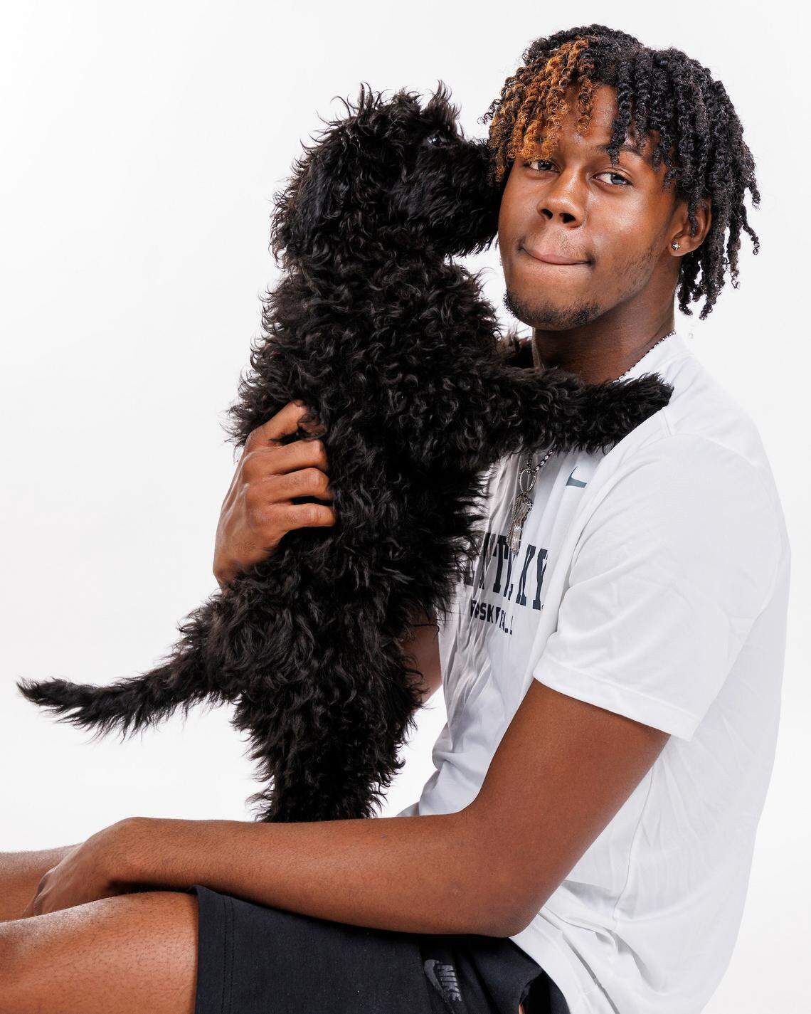Kam Williams poses with his labradoodle, Knight, during a National Dog Day photo shoot for the UK men’s basketball team.
