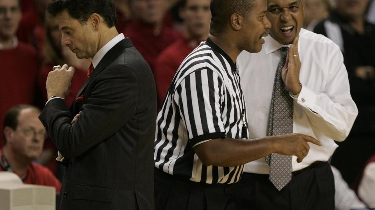 Louisville Coach Rick Pitino, left, heads back to the bench as referee Gerald Boudreaux tells Tubby Smith that Patrick Sparks was fouled with less than one second left on the clock and would go to the line for three free throws in the Cats’ game against the Cards on Dec. 18, 2004.