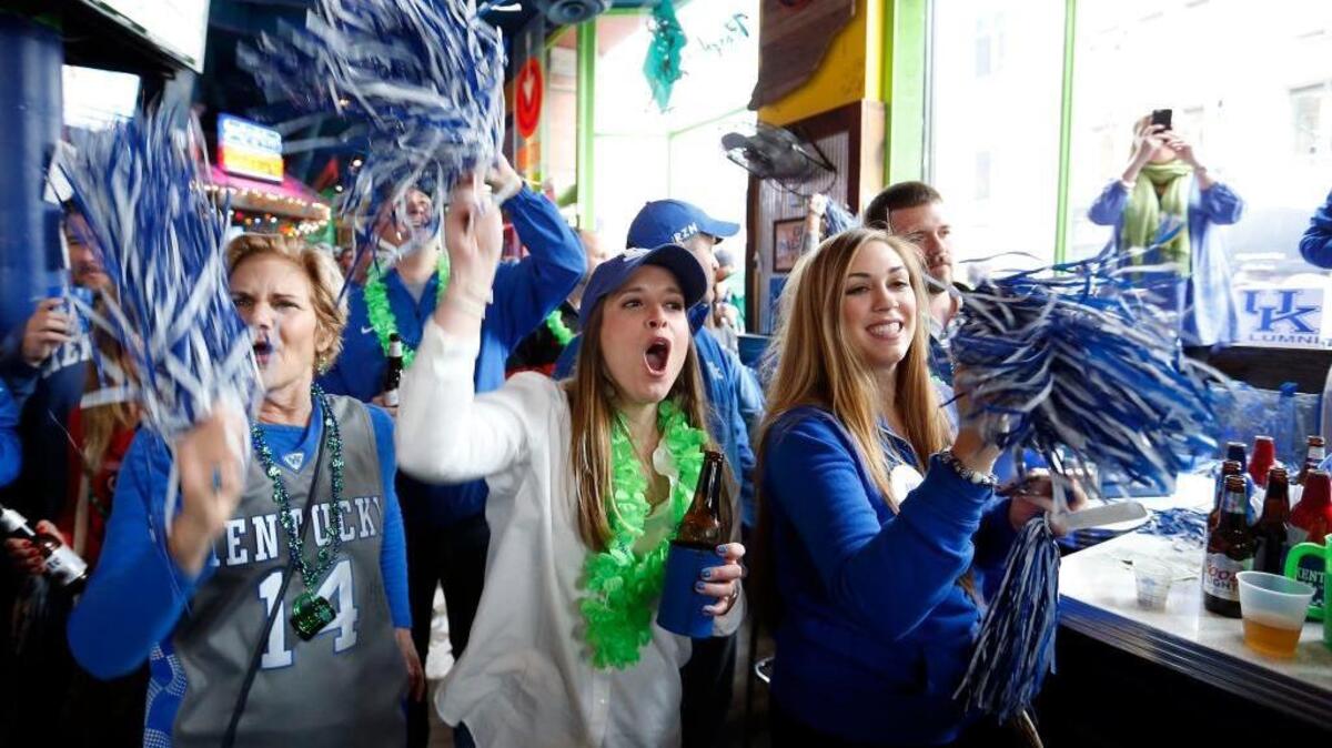 UK fans from left, Sheridan Marr, Jenna Ballard and Carrie Wood, cheered durign a Kentucky pep rally held at the Tin Roof before UK played Northern Kentucky University in a first-round NCAA Tournament game last March. Tin Roof is among a number of popular locations to take in UK games.