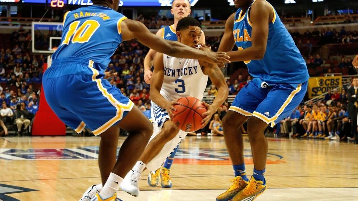 Kentucky Wildcats guard Tyler Ulis (3) drives through UCLA Bruins guard Isaac Hamilton (10) and forward Kevon Looney (5) during the second half at the United Center Saturday, Dec. 20, 2014 in Chicago, Ill.