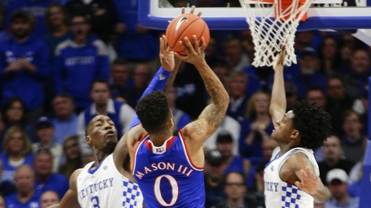 Kansas guard Frank Mason III soared between Kentucky’s Bam Adebayo, left, and De’Aaron Fox for two of his 21 points in last season’s 79-73 Jayhawks victory in Rupp Arena.
