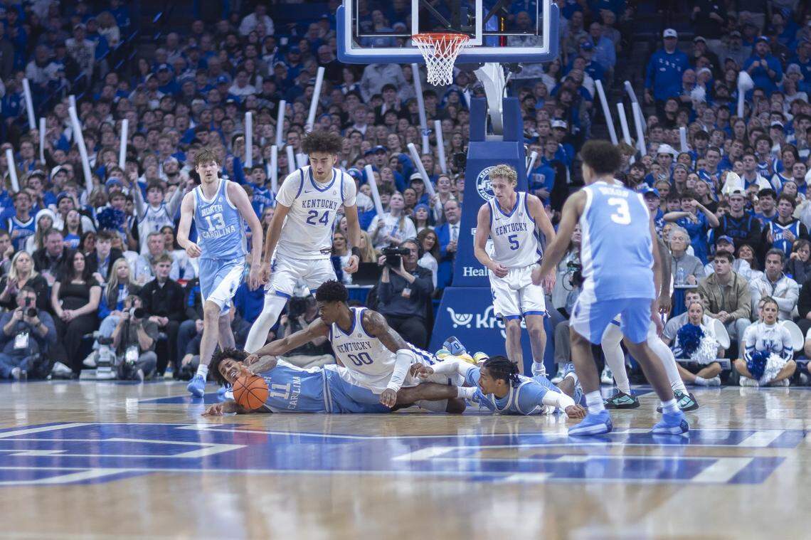 Kentucky Wildcats guard Otega Oweh (00) and North Carolina Tar Heels forward Jonathan Powell (11) struggle for the ball during a game at Rupp Arena in Lexington, Ky., on Tuesday, Dec. 2, 2025.