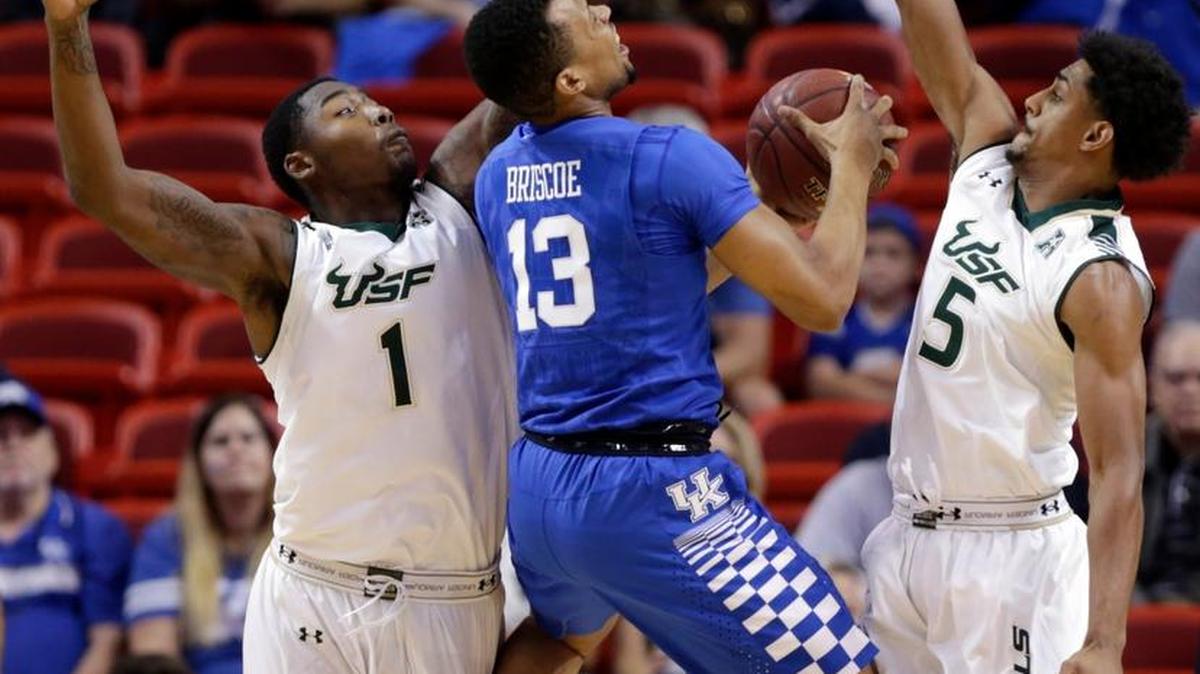 UK’s Isaiah Briscoe (13) went up for a shot while pressured by South Florida’s Chris Perry (1) and Nehemias Morillo on Friday. Kentucky Coach John Calipari accused Briscoe of playing “a little bit … casual.”