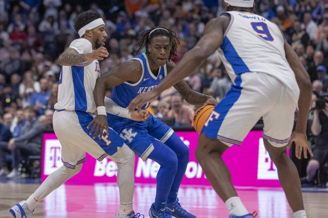 Kentucky guard Denzel Aberdeen (1) attempts to move the ball as Florida Gators guard Boogie Fland (0) and Florida center Rueben Chinyelu (9) defend during the SEC Tournament at Bridgestone Arena in Nashville, Tennessee, on Friday. 