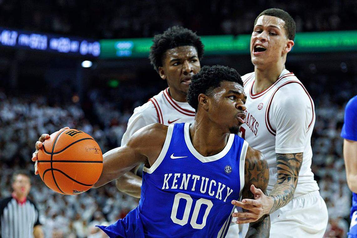 Kentucky’s Otega Oweh (00) drives to the basket in the second half against Arkansas’ Trevon Brazile (right) at Bud Walton Arena in Fayetteville, Arkansas, on Saturday. The Wildcats defeated the Razorbacks 85-77. 
