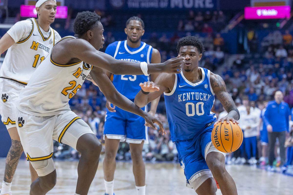 Kentucky Wildcats guard Otega Oweh (00) drives the ball as Missouri Tigers forward Mark Mitchell (25) defends during the SEC Tournament at Bridgestone Arena in Nashville, Tenn., on Thursday, March 12, 2026.