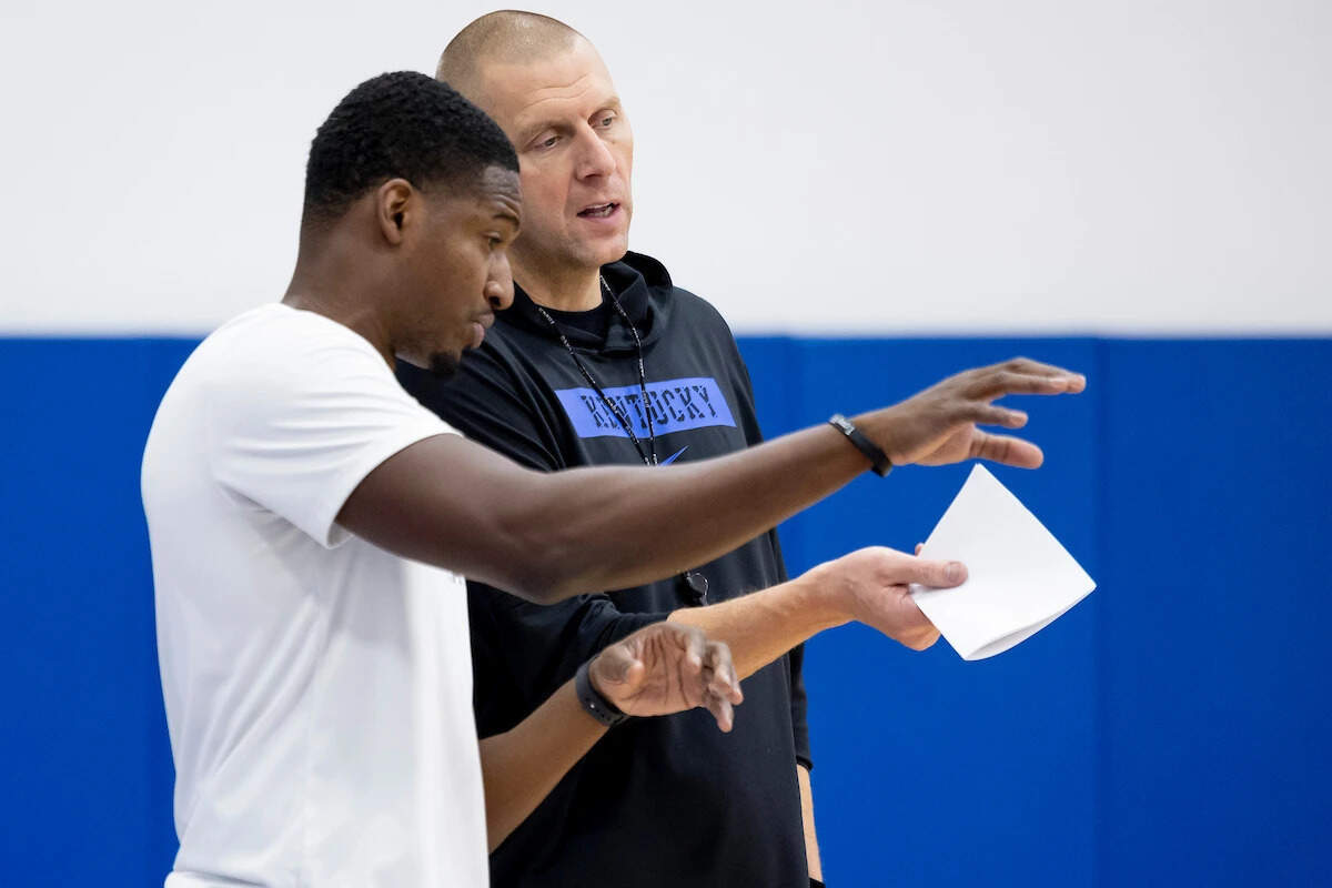 UK assistant coach Mikhail McLean, left, consults with head coach Mark Pope during one of Kentucky’s practices last season.