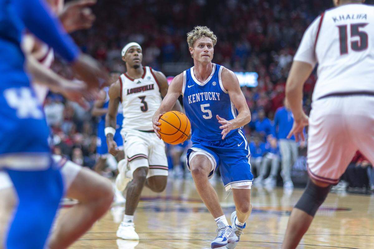 Kentucky Wildcats guard Collin Chandler (5) drives the ball past Louisville Cardinals guard Ryan Conwell (3) during a game at the KFC Yum! Center in Louisville, Ky., on Tuesday, Nov. 11, 2025.