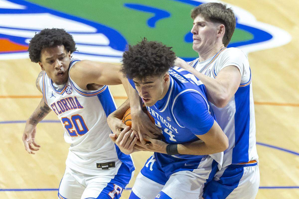 Kentucky center Malachi Moreno grabs a rebound in front of Florida players Isaiah Brown Alex Condon (21) during a loss to the Gators on Feb. 14.