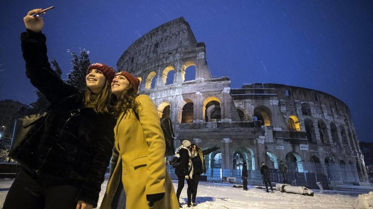 Two women took a selfie in front of the ancient Colosseum during a snowfall in February. It should be much warmer when the Kentucky women take an international tour there in August.