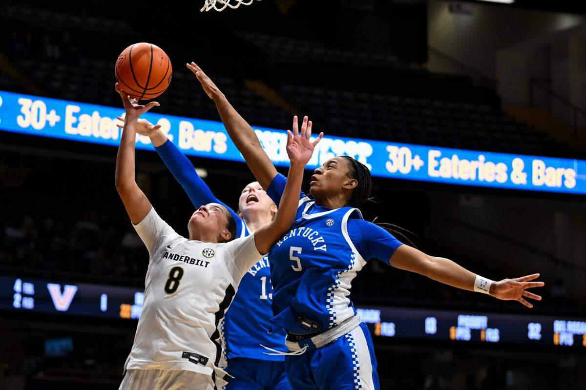 Vanderbilt’s Ava Black (8) drives to the basket against Kentucky’s Tonie Morgan (5) and Clara Strack (13) in the second half of a game at Memorial Gymnasium on February 22 in Nashville, Tennessee. 