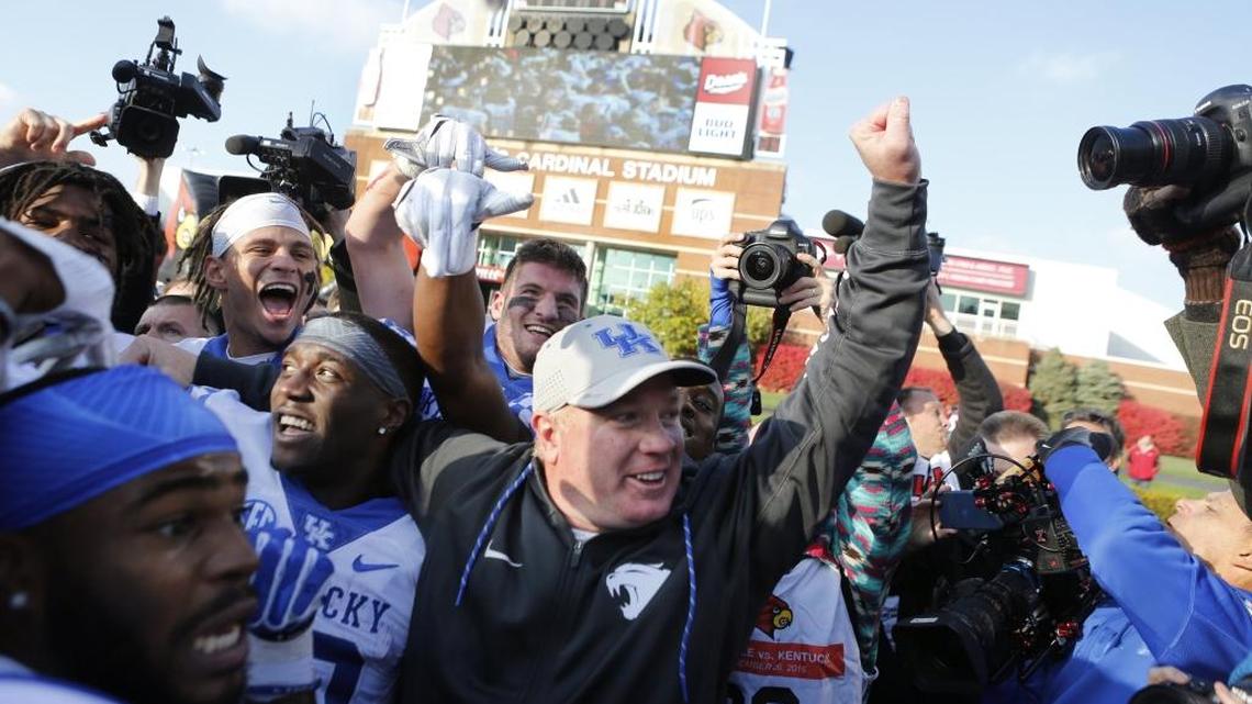 Kentucky head coach Mark Stoops celebrated with his team after the Wildcats’ win over Louisville, UK’s seventh win in their last 10 games of the regular season. The Cats take on Georgia Tech in the TaxSlayer Bowl on Saturday.