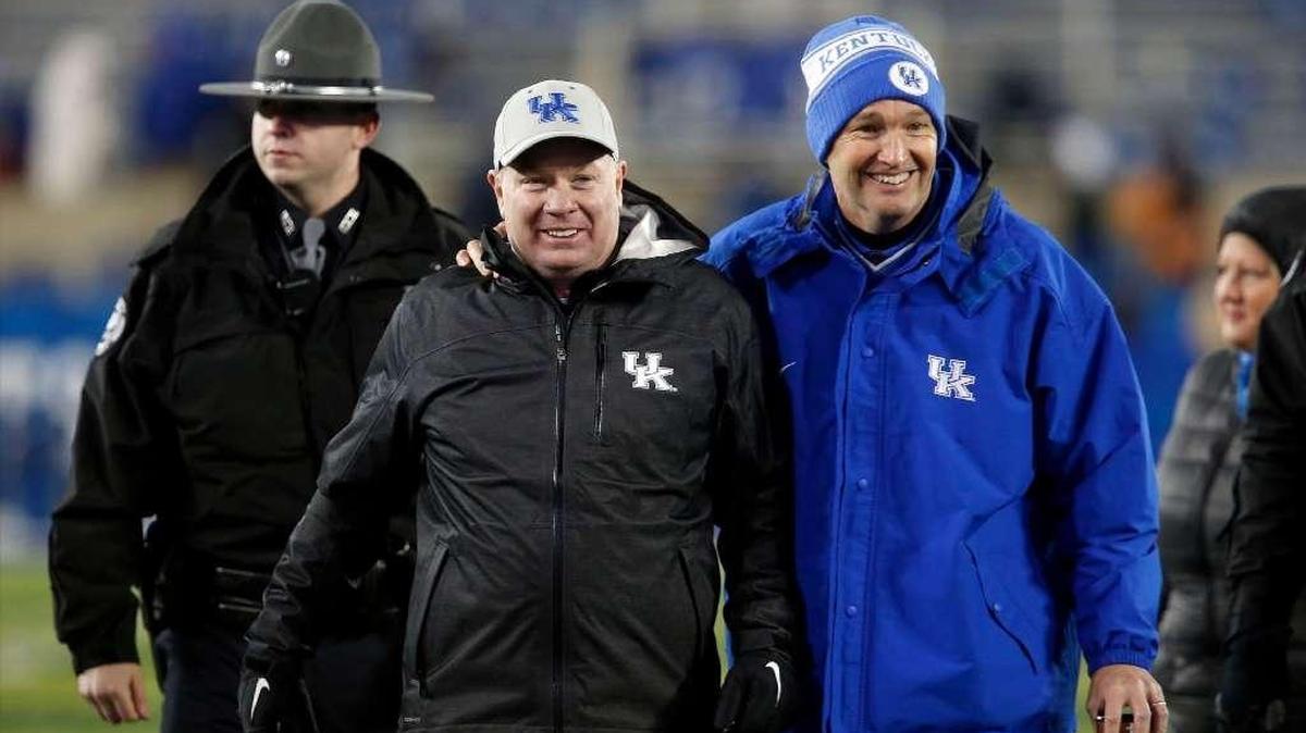 Kentucky football coach Mark Stoops, left, and Athletics Director Mitch Barnhart walked off the field together after UK’s 58-10 win over Charlotte on Nov. 21, 2015.