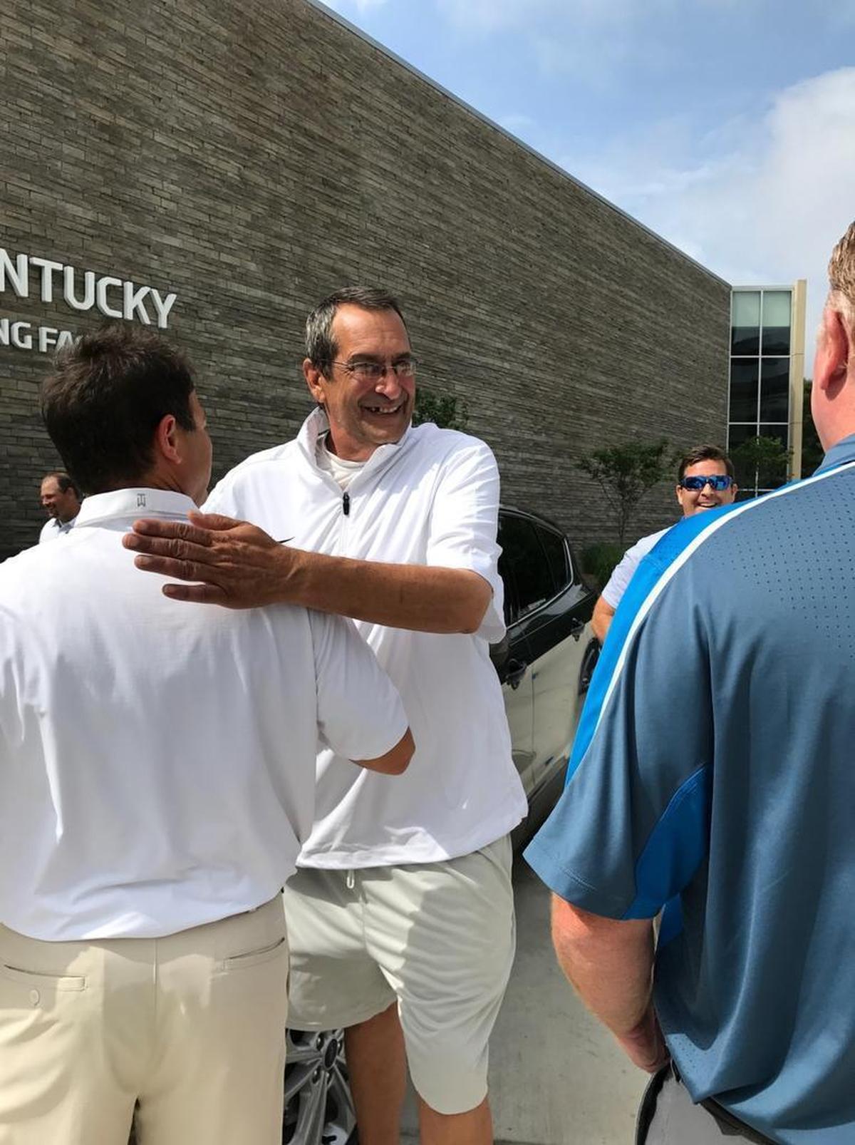 Longtime Kentucky football equipment manager Tom Kalinowski, middle, was congratulated by UK director of football operations Frank Buffano as head coach Mark Stoops, right, watched. Kalinowski was surprised last month with a new Ford Escape from Paul Miller Ford. Many former players as well as coaches and staff members chipped in to get him the new vehicle.