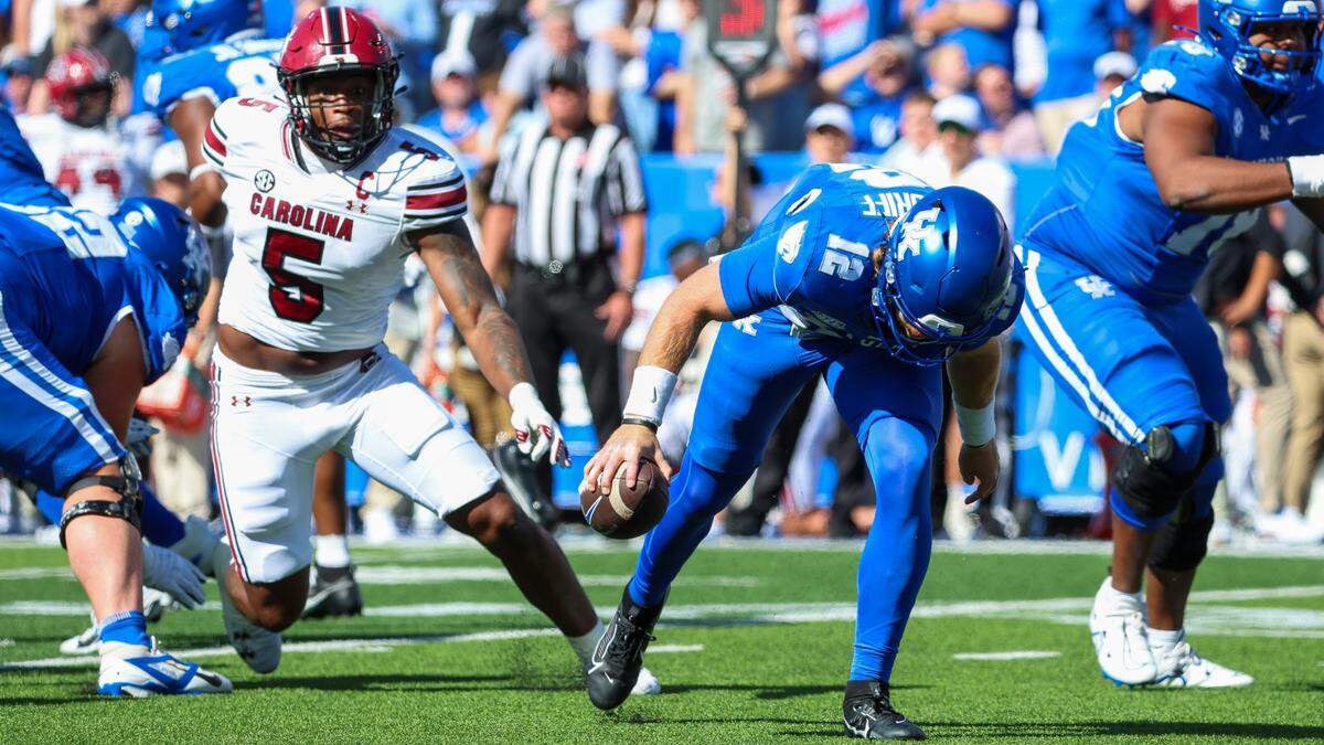 Kentucky quarterback Brock Vandagriff (12) stumbles under pressure from South Carolina edge rusher Kyle Kennard (5) during Saturday’s game against South Carolina.