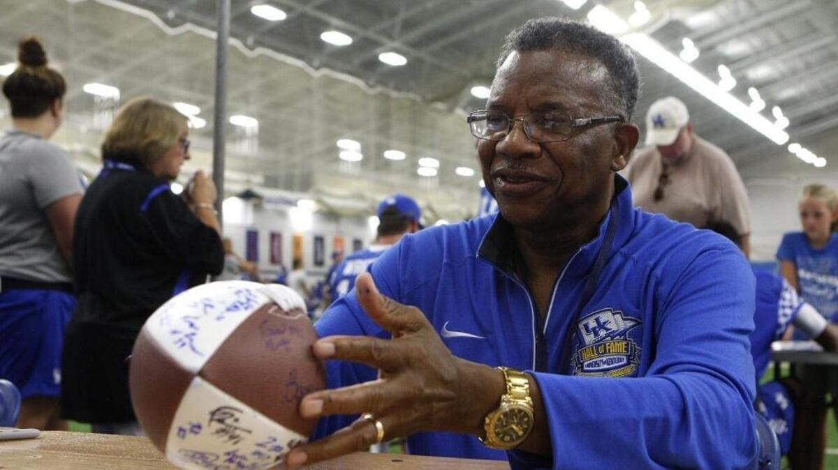 Former UK player Nate Northington, who was a pioneer in integrating the SEC, autographed a ball for a fan during UK Football Fan Day inside Nutter Field House in Lexington, Ky., Saturday, August 6, 2016.
