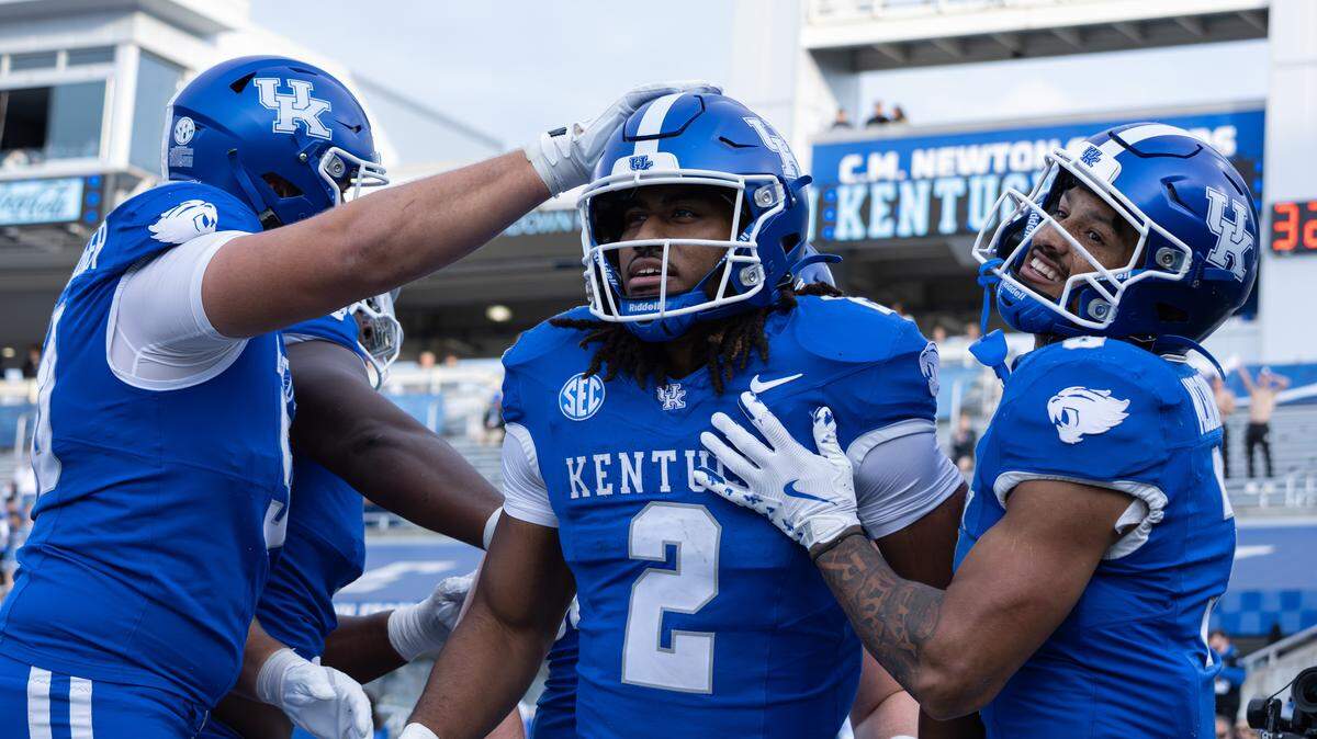 Kentucky football teammates celebrate with running back Dante Dowdell (2) after he scored a touchdown during a win over Tennessee Tech last Saturday at Kroger Field. 