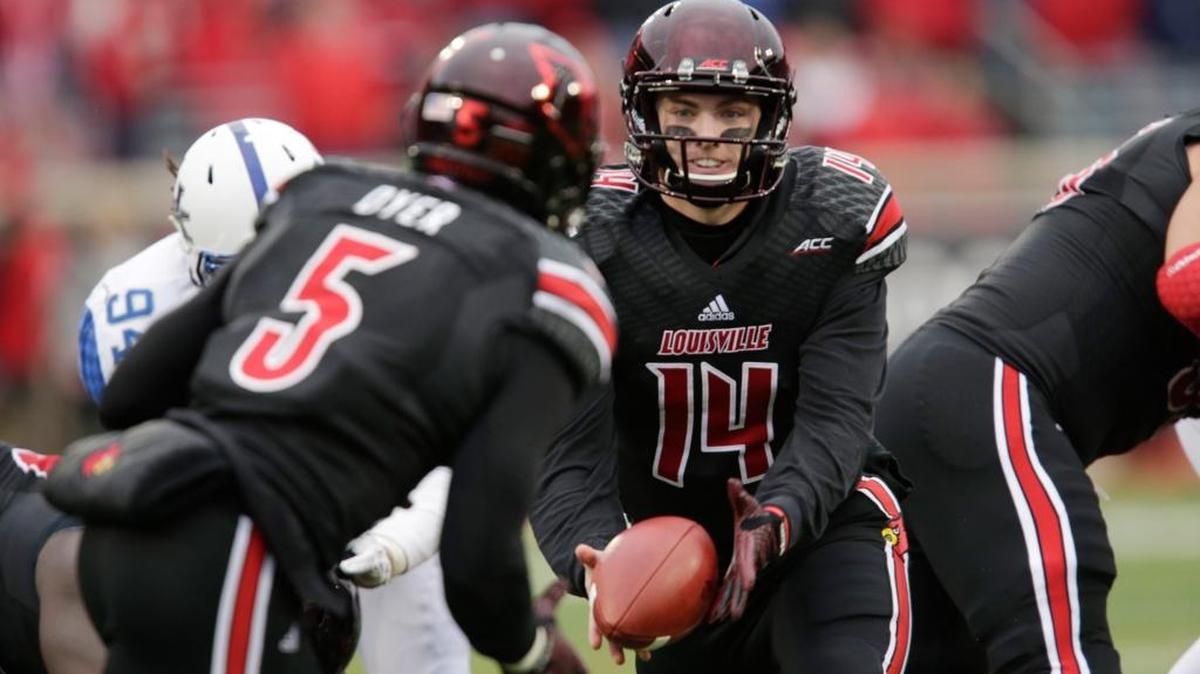 Louisville Cardinals's Kyle Bolin (14) a Lexington Catholic graduate handed the ball off to Louisville Cardinals's Michael Dyer (5) in the third quarter of the Kentucky at Louisville football game at Papa John's Cardinal Stadium in Louisville, Ky., on Nov. 29, 2014. Louisville won 44-40. Photo by Pablo Alcala | Staff